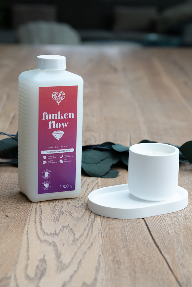 Ein fertiges Gießpulver-Set (Schälchen auf Tablett) neben einer Flasche Funkenflow Booster von Herzfunken.